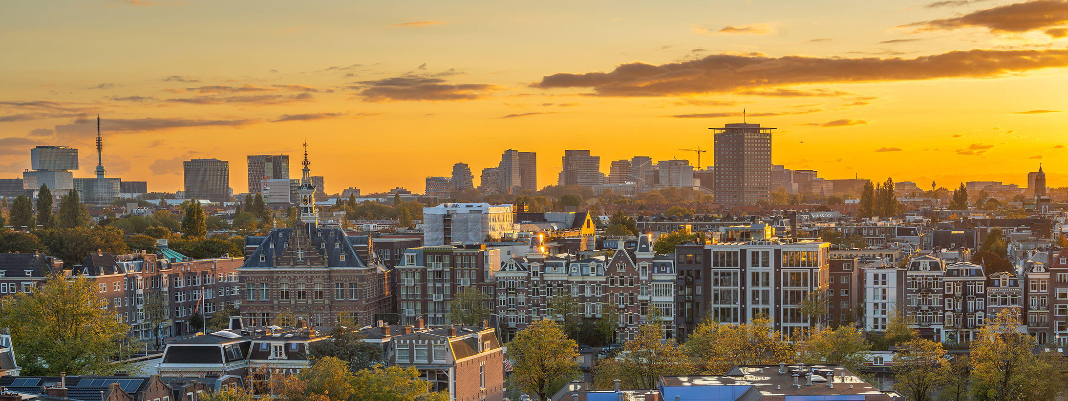 Skyline van Amsterdam in de herfst bij zonsondergang, zicht op de Rivierenbuurt en de Zuidas